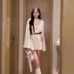 Elegant women's poncho coat in Beige with cape sleeve and gold button details.